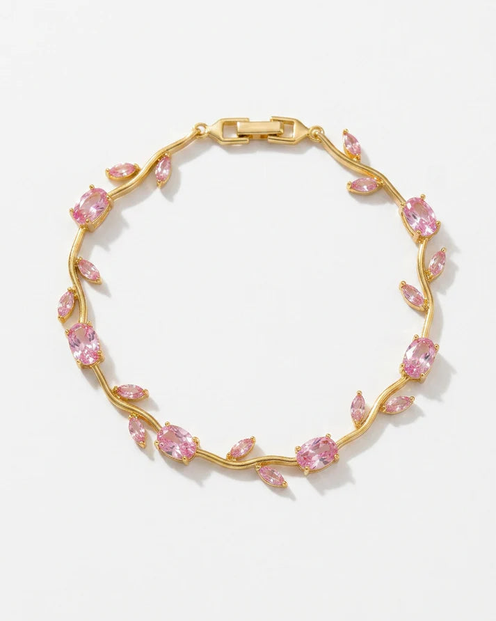 A gold vine bracelet adorned with marquise-cut pink gemstones, displayed on a clean white background.