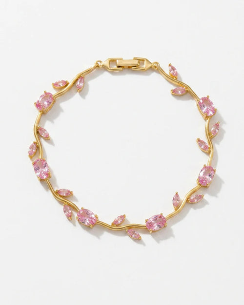 A gold vine bracelet adorned with marquise-cut pink gemstones, displayed on a clean white background.
