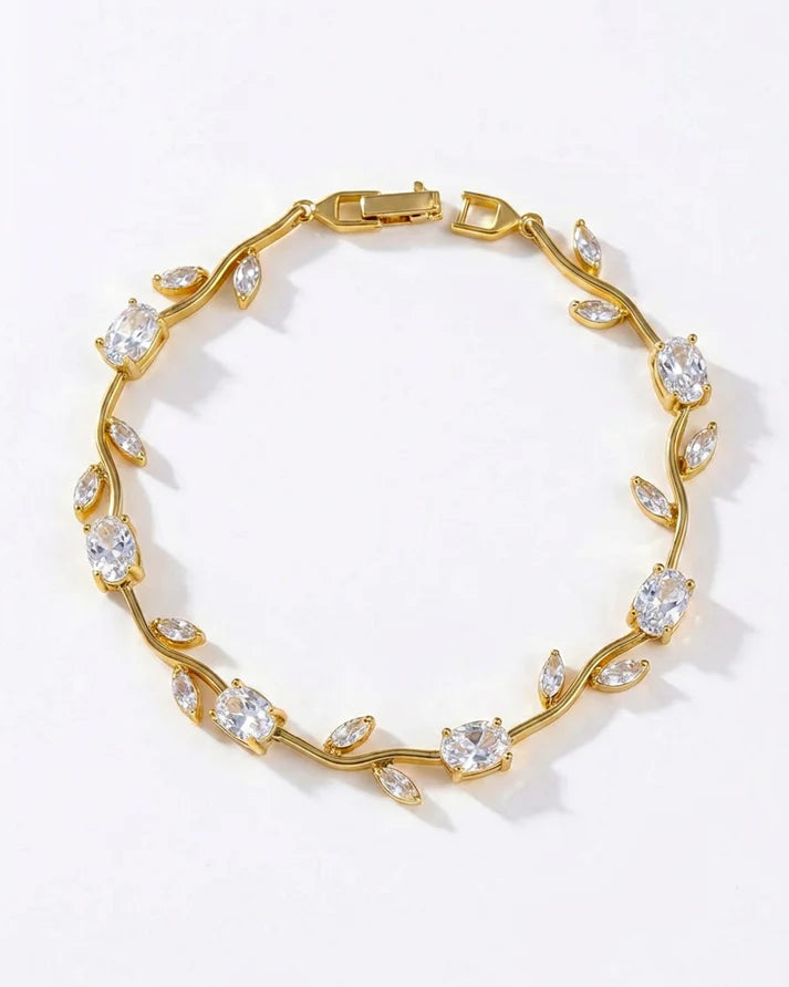 A gold vine-style bracelet adorned with clear marquise and oval gemstones, displayed on a clean white background.