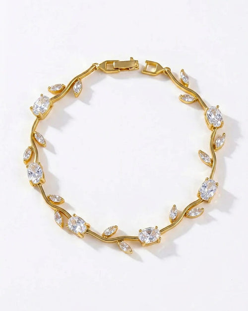 A gold vine-style bracelet adorned with clear marquise and oval gemstones, displayed on a clean white background.